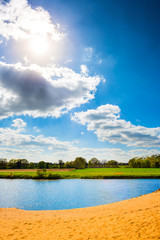 See mit Sandstrand bei strahlendem Sonnenschein