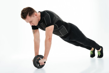 Full length portrait of a concentrated healthy sportsman doing exercises