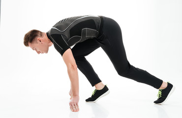 Obraz premium Portrait of a young concentrated sportsman ready to start running