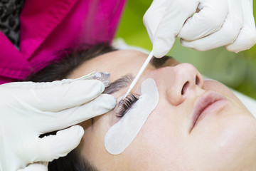Woman on the procedure for eyelash extensions, eyelashes lamination 