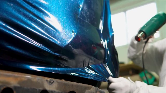 Expert in the garage smooth surface of the machine, pasted vinyl, vinyl film edge tucked further dried dryer, to cover well fixed.