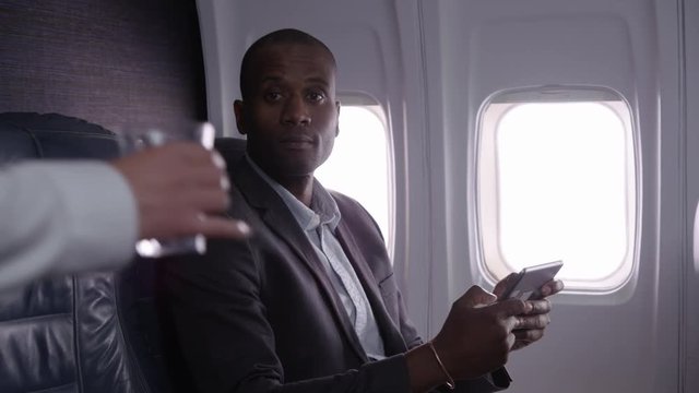 Businessman using digital tablet on airplane