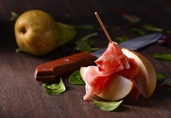 prosciutto with pear on a wooden table