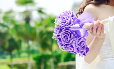Bride holding her bouquet behind her back