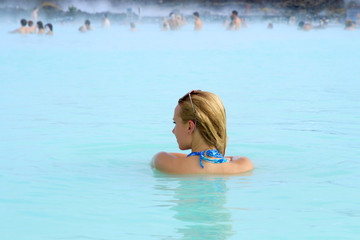 A woman enjoys spa in hot spring Blue Lagoon in Iceland
