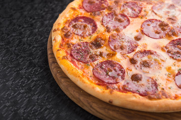 Closeup of hot pizza with salami sausage