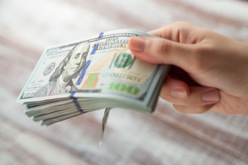 Many dollars falling on woman's hand with money