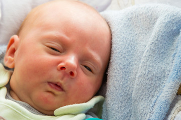 Little newborn baby lying in blanket