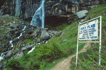 In the front white sign on background jogini waterfall