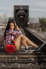 Fashionable Beautiful women sitting on train tracks