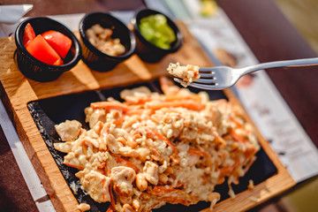 Fork with rice above chicken with peanut and rice