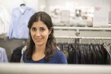 Woman buying clotes in mall looking at camera