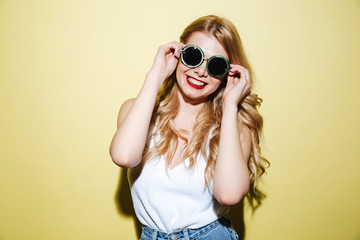 Smiling happy blonde woman wearing sunglasses and looking at camera