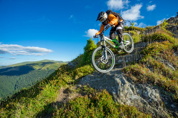 Fototapeta na wymiar A man is riding bicycle, on the background of mountains and blue sky. Beautiful summer day.