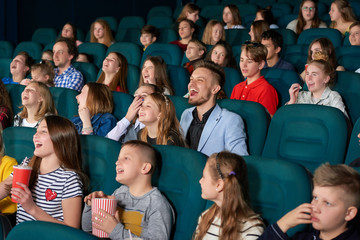 Happy little kids laughing watching a comedy movie at the local cinema people exciting amazing emotional expressive funny positivity leisure hobby lifestyle concept.
