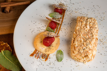 Napoleon cake on plate with cookies and strawberries