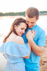 Fototapeta na wymiar Young couple in love hug each other at the lake outdoor in summer day, harmony concept