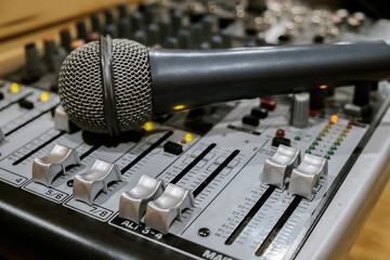 Microphone in soft focus placing on audio synthesiser electronic music instrument sound mixer...