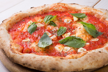 Whole pizza on wooden board