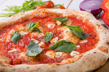 Whole pizza on wooden board