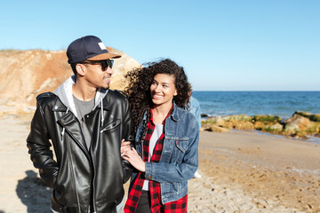 African loving couple walking outdoors at beach