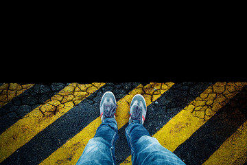 Top view of a person standing in front of the black dangerous precipice. Point of view perspective...