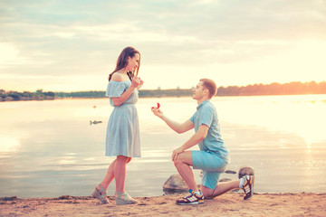 Marriage proposal on sunset . young man makes a proposal of betrothal to his girlfriend