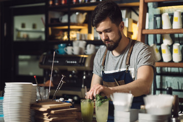 Young male bartender preparing an alcohol cocktail