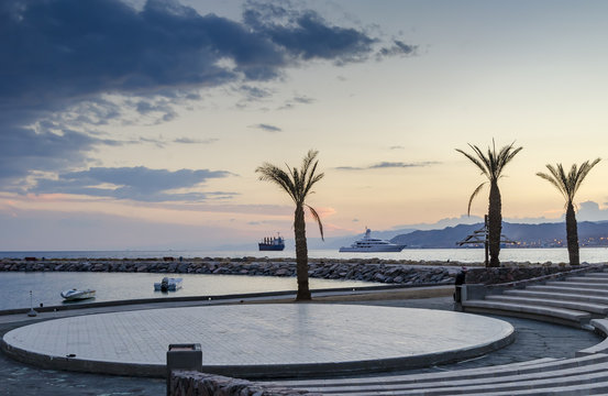 Colorful sunset at the Red Sea; view from stone amphitheater on central beach of Eilat - famous resort and recreational city in Israel