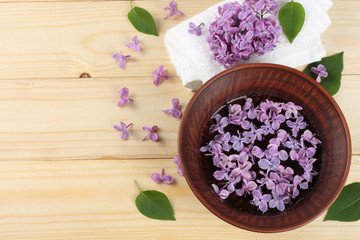 spa lilac flower in water on wood background