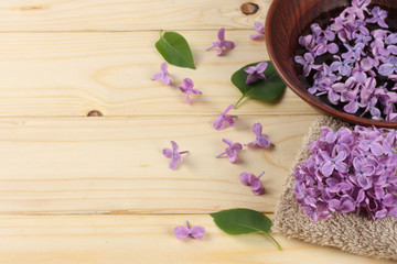 spa lilac flower in water on wood background