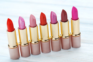 Obraz premium Colorful lipsticks on blue wooden table