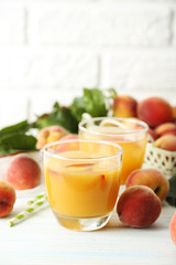 Glasses of peach juice on white wooden table