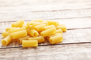 Pasta penne on the brown wooden table