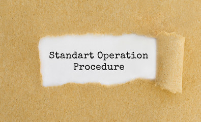 Text Standart Operation Procedure appearing behind ripped brown paper
