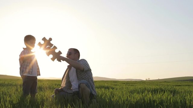 Father and son playing in the field at the day time. People having fun outdoors. Concept of friendly family.
