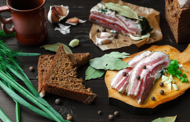 Baked Ham with bread and spices on a dark table