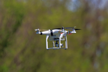 Drone quadrocopter flying against the background of trees