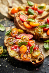 Tomato bruschetta with grilled homemade bread with cheese and fresh herbs - obrazy, fototapety, plakaty