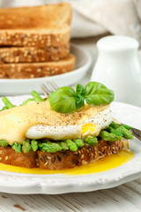 Bread toast with sesame and flax seed, asparagus, poached egg and hollandaise sauce. A traditional Breakfast. Selective focus