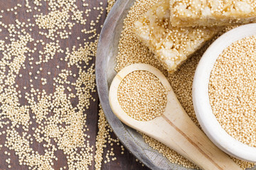 Amaranth seeds and energy bars on wood