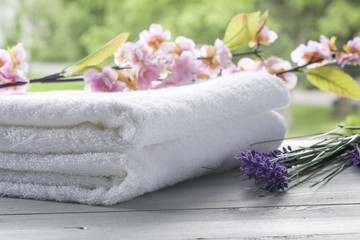Fototapeta na wymiar Composition of towels and flowers. Spa therapy concept