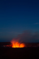 Fototapeta na wymiar Ein Lavasee im Halemaumau Krater auf dem Kilauea beleuchtet aufsteigende vulkanische Dämpfe vor dem Nachthimmel im Hawaii Volcanoes National Park auf Big Island, Hawaii, USA.