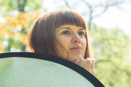 Reflector. The Girl Is Holding A Light Reflector.