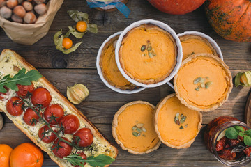  Pie with cherry tomatoes, pumpkin pie, orange and paper bag with nuts
