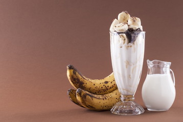 Milkshake with banana and chocolate on a brown background