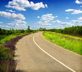 Fototapeta na wymiar Empty curved road,blue sky and clouds 