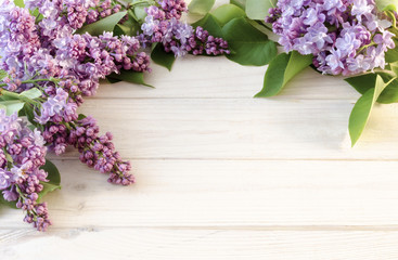 Flowering lilac branches on a wooden background