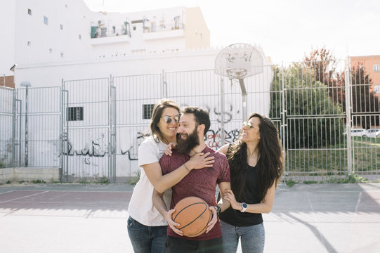 Three friends playing basketball together