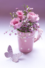 Lisianthus mit Wachsblumen und Schleierkraut in einer Tasse mit Schmetterling